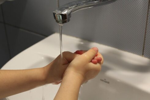 criança lava as mãos