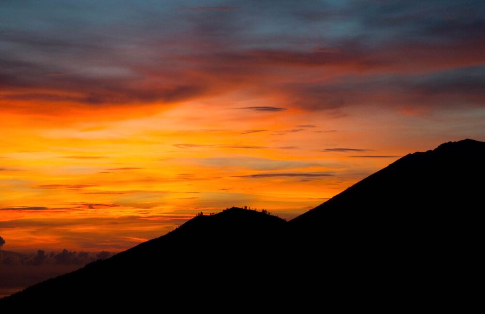 Entardecer com montanhas ao fundo e céu alaranjado